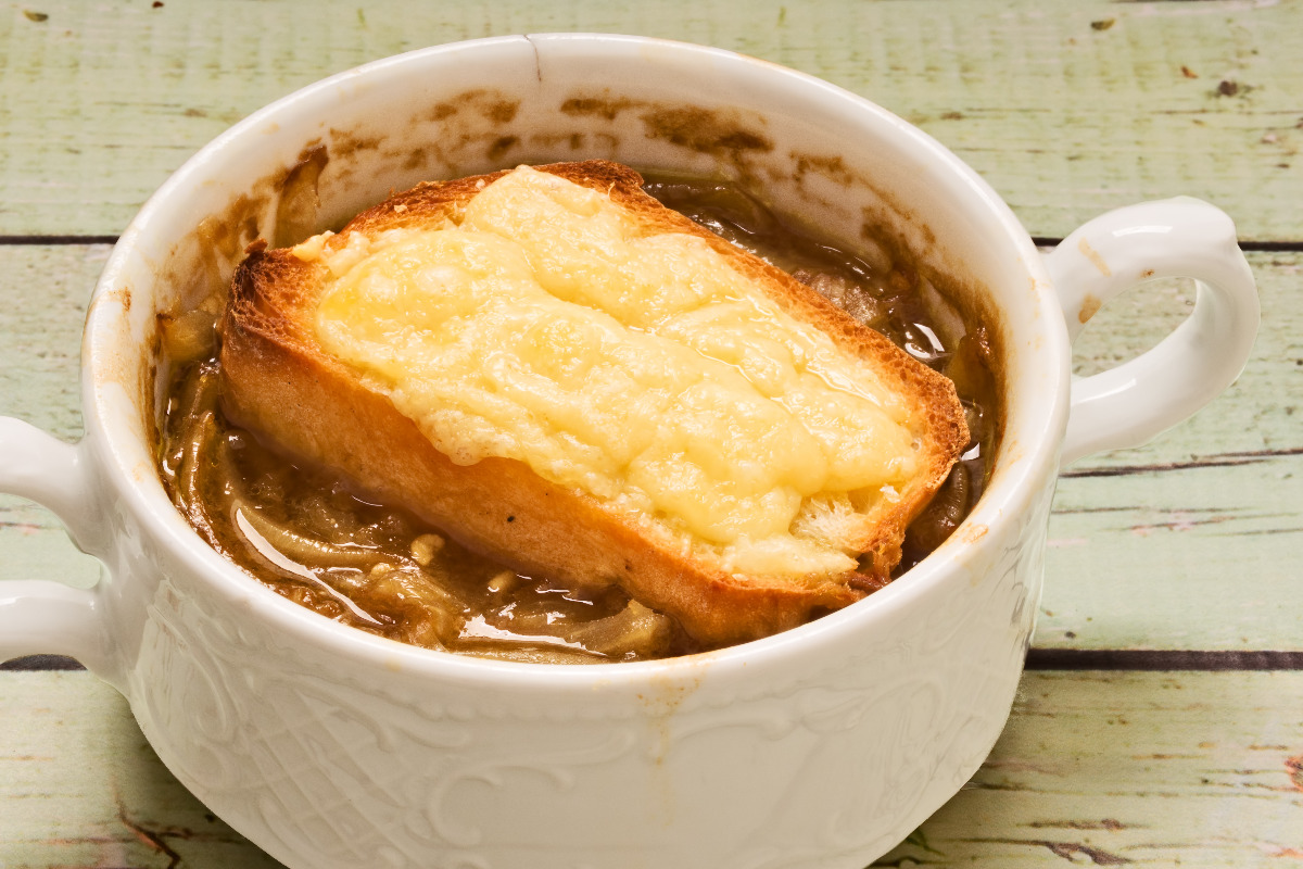 A delicious bowl of French onion soup with toasted bread on top.