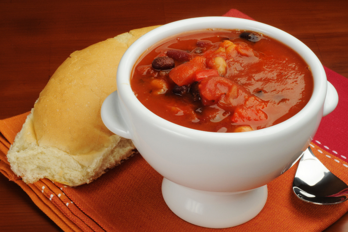 A delicious bowl of tomato soup with a side of bread.