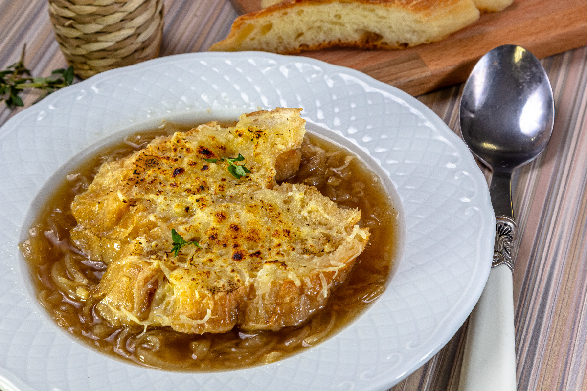 A bowl of French onion soup with toasted bread and cheese.